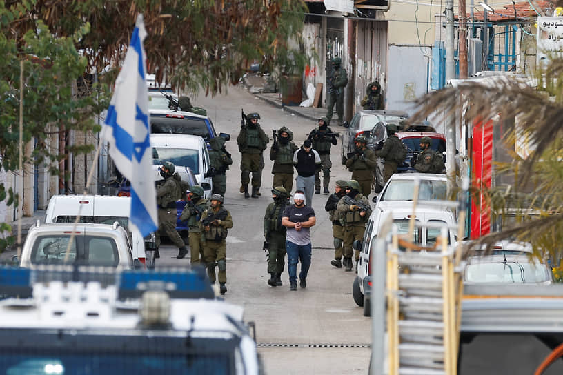 Израильские солдаты задерживают палестинцев во время рейда в Рамалле на контролируемом Израилем Западном берегу