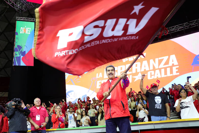 Президент Николас Мадуро размахивает флагом на съезде Единой социалистической партии, на котором он был выдвинут кандидатом в президенты Венесуэлы