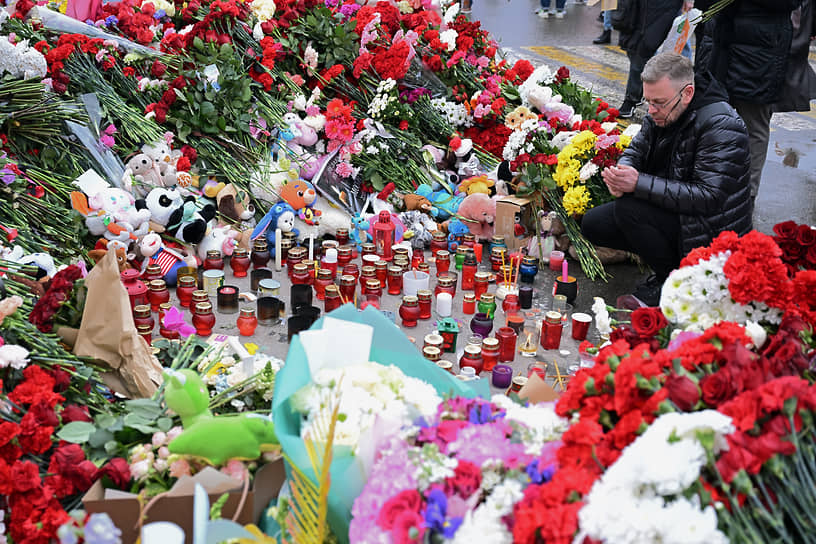 Свечи и цветы у стихийного мемориала в память о погибших в результате теракта 22 марта