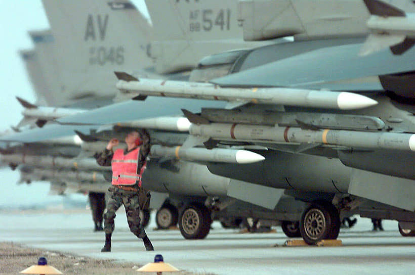 Начальник боевого расчета проверяет расположение ракет на американском F-16, готовясь к его запуску в рамках авиаударной операции НАТО, 25 марта 1999 года, на авиабазе в Италии