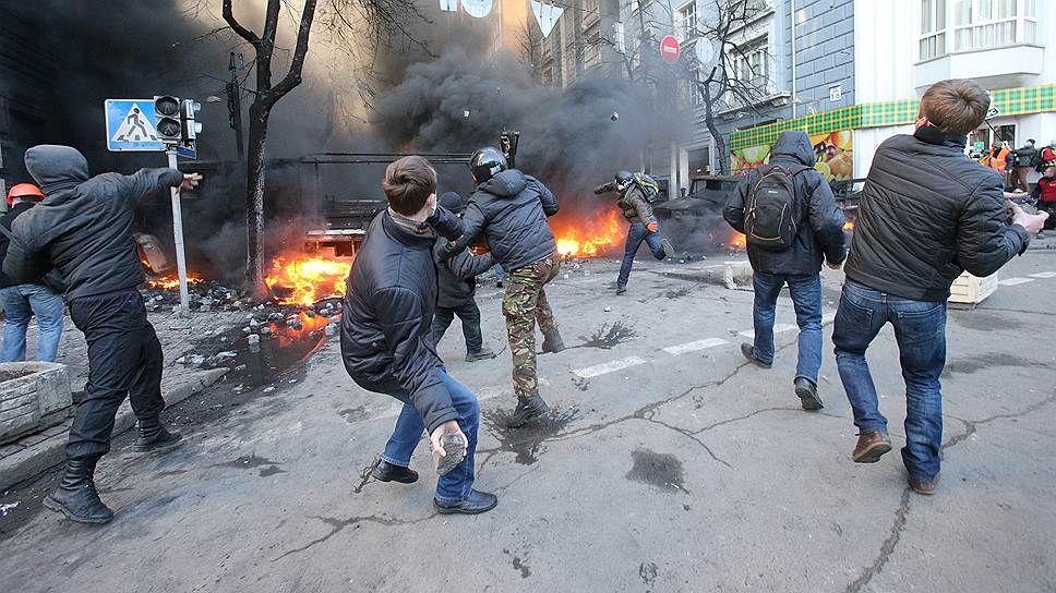 Во время противостояния на улице Институтской. Активисты Майдана бросают камни в сторону милиции. 
