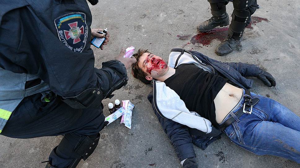 Сотрудник милиции оказывает первую помощь пострадавшему после разгона на улице Институтской.
