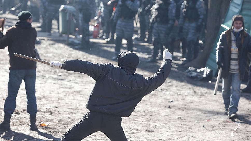 Титушки бросают камни рядом с бойцами спецподразделения Беркут в Мариинском парке.
