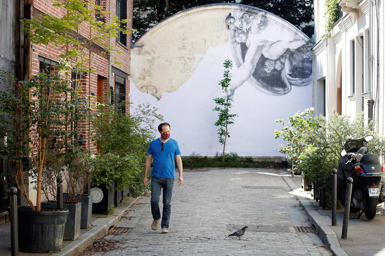 Фреска, вдохновленная «Сотворением Адама» Микеланджело, на стене в Париже, 2020 год.