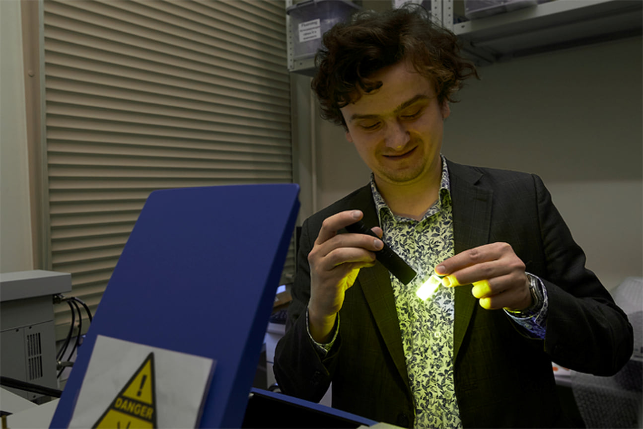 Сотрудник лаборатории Юрий Белоусов изучает люминесценцию синтезированного комплекса
