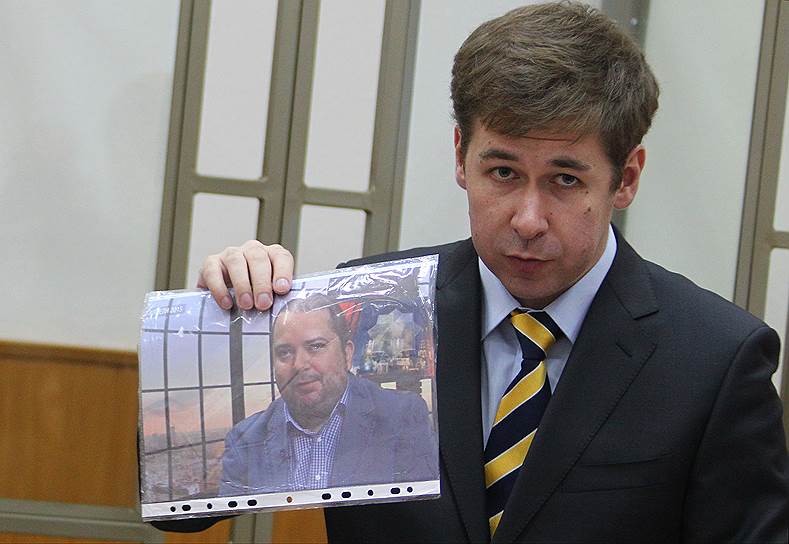 Адвокат Илья Новиков с фотографией политконсультанта, члена общественной палаты Москвы Павла Карпова 