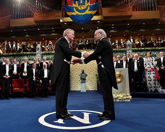 Лауреат Нобелевской премии в области медицины и физиологии Майкл Янг (слева) получает награду из рук короля Швеции Карла XVI Густава