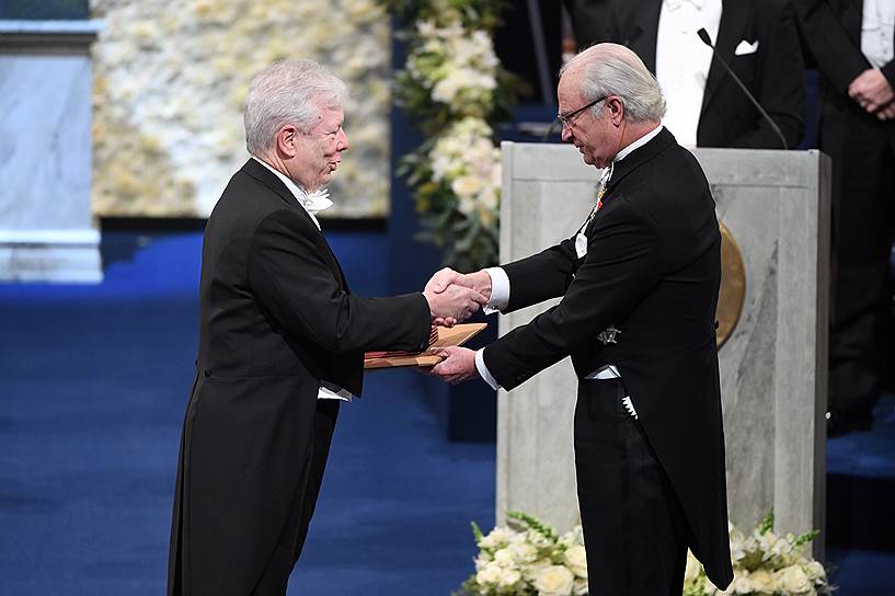Американец Ричард Талер (слева) получает Нобелевскую премию по экономике из рук короля Швеции Карла XVI Густава