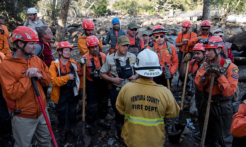 Монтесито, штат Калифорния (США). Волонтеры (в оранжевом) слушают инструктаж спасательных бригад 
