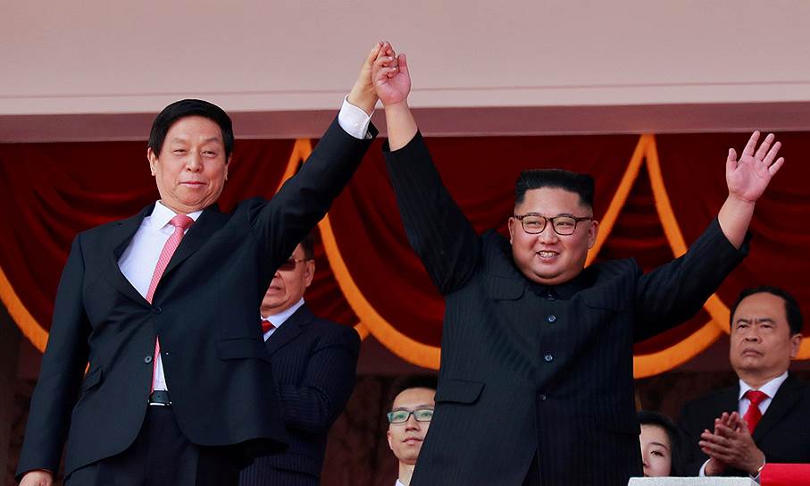 Лидер Северной Кореи Ким Чен Ын (справа) и глава постоянного комитета Всекитайского собрания народных представителей Ли Чжаньшу на трибуне во время парада в Пхеньяне