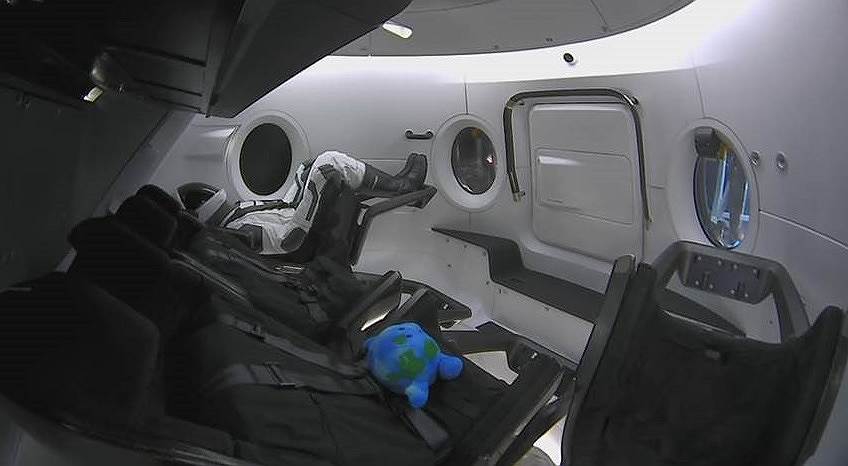 Манекен и индикатор невесомости в кабине космического корабля Crew Dragon