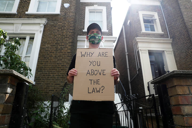 Мужчина с протестным плакатом около дома Доминика Каммингса