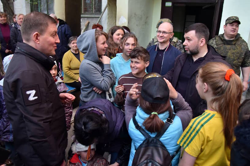 Андрей Турчак (слева),  Сергей Кириенко (второй справа) и Денис Пушилин во время встречи с местными жителями в Мариуполе.