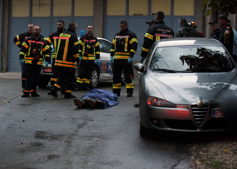 Пожарные стоят у тела на месте стрельбы в Цетине