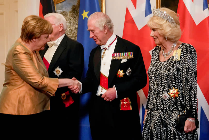 Бывший канцлер Германии Ангела Меркель пожимает руку королю Великобритании Карлу III и Камилле