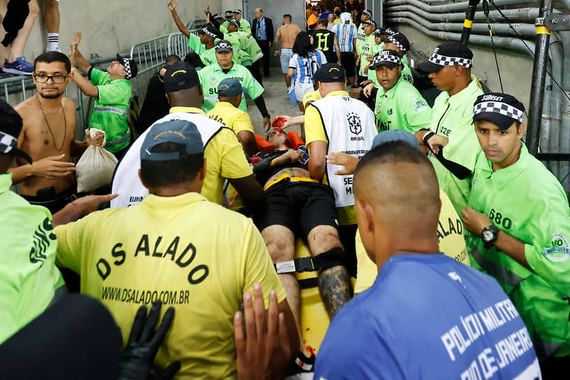 Пострадавшего болельщика выносят со стадиона Маракана в Рио-де-Жанейро