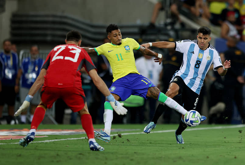 Бразильский нападающий Рафинья (в центре), аргентинский вратарь Эмилиано Мартинес (слева) и защитник Маркос Акунья