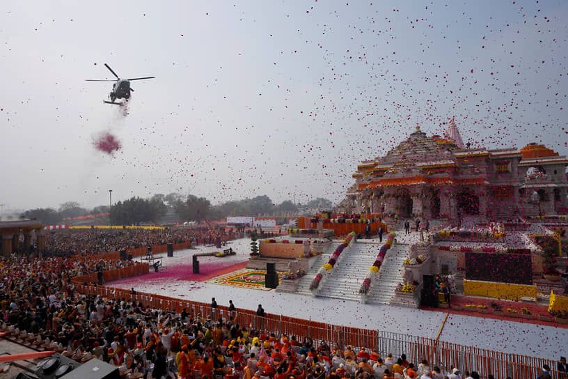 Вертолет ВВС Индии осыпает толпу лепестками цветов во время церемонии открытия храма