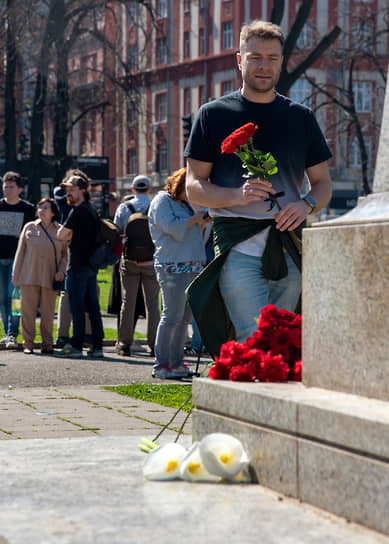 Белград, Сербия. Мужчина несет цветы к памятнику Александру Пушкину
