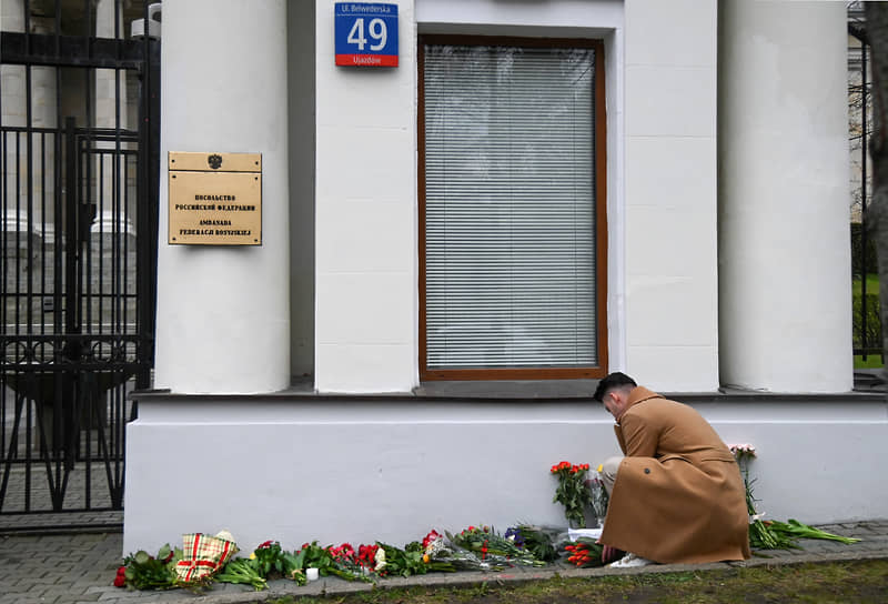 Варшава, Польша. Люди возлагают цветы возле посольства России 