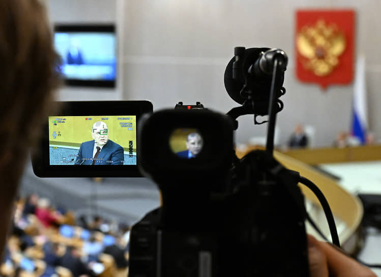 Михаил Мишустин на экране во время заседания Госдумы