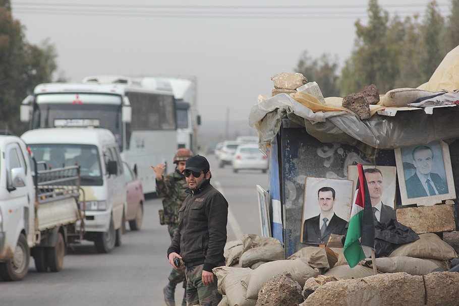 Блокпост на пути в город Дераа, где год назад начались протесты. Портреты президентов Асадов, отца и сына,— это как знамя 