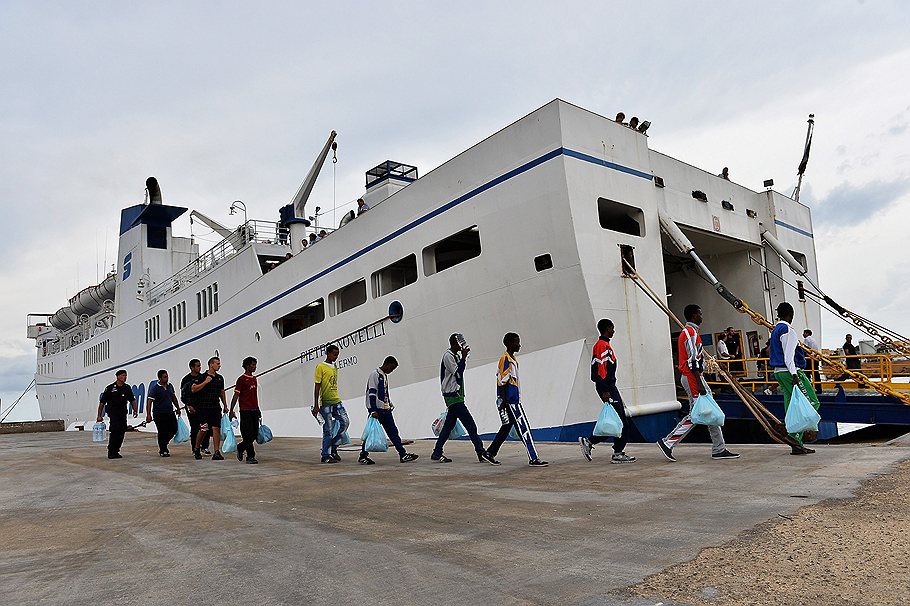 Этим иммигрантам повезло: они не потонули по пути на Лампедузу и грузятся на корабль, чтобы доплыть до очередного фильтрационного лагеря на Сицилии 