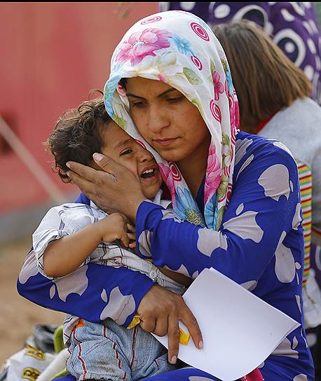 Эта курдская беженка со своим ребенком уже в безопасности — по ту сторону турецко-сирийской границы, у турецкого города Сурук. Проблема в том, что, по данным ООН, Турция может не справиться с потоком беженцев 
