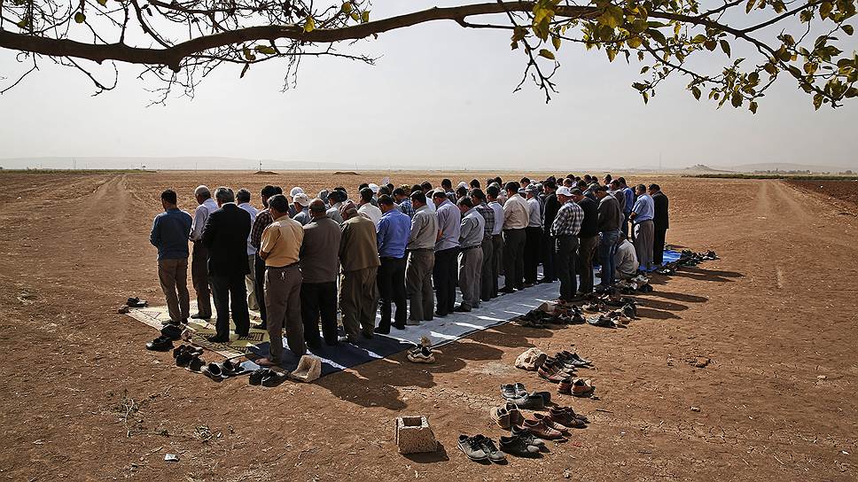 Эти курды молятся на одной из окраин Сурука и, возможно, кто-то из них отправится помогать собратьям в соседний Кобани 
