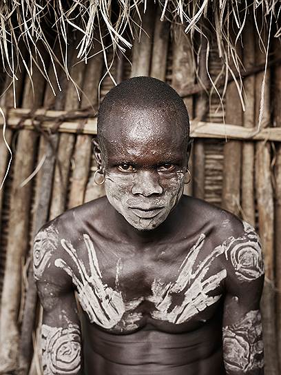 Аборигены рисуют смесью белой глины и золы на своем теле 
