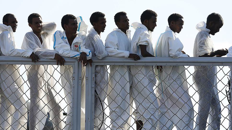 Мигранты, спасенные итальянскими военными моряками у ливийского побережья, ждут высадки в Сицилии 
