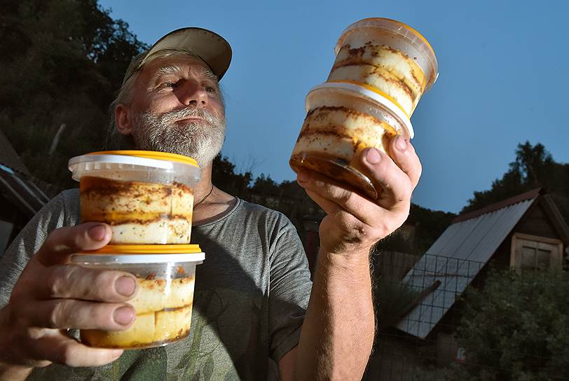 Юрий Карамзин кладет сыр в банки с оливковым маслом 
