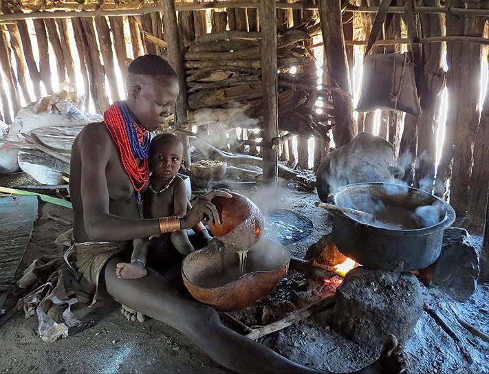 Женщина из племени каро готовит обед 