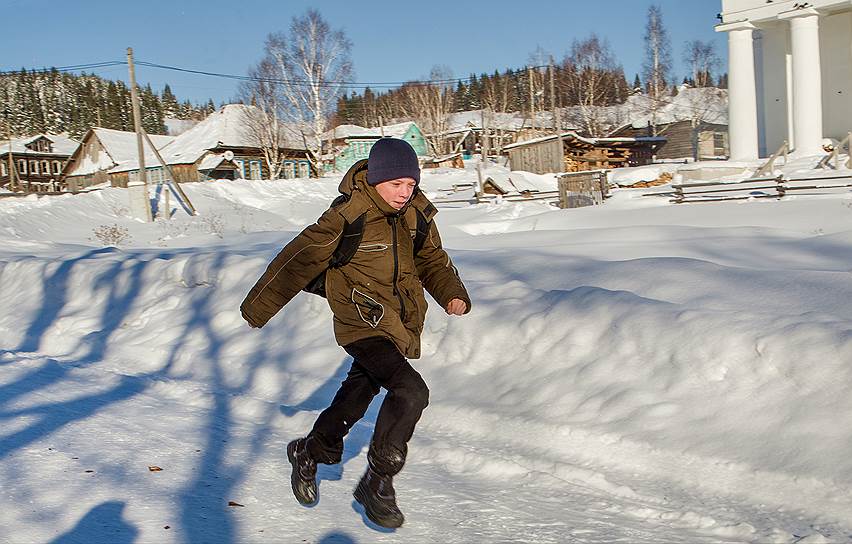 Школьник бежит по расчищенной от снега дороге