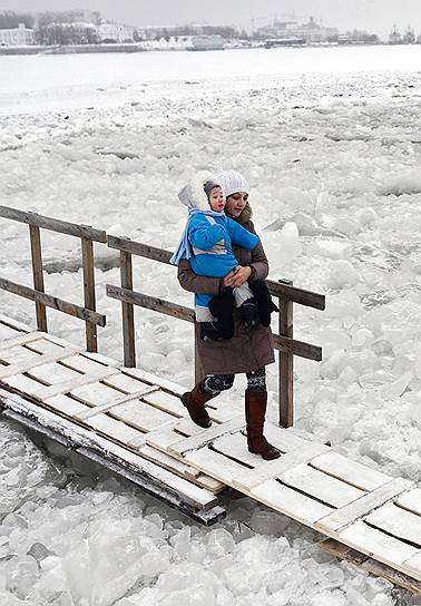 Женщина с ребенком на ледовой переправе через Северную Двину
