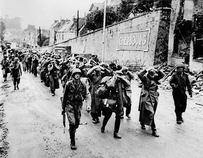 Американские солдаты ведут пленных после тяжелых боев за нормандский порт Шербур