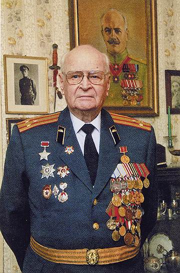 Полковник Владимир Сафир у себя дома. Сзади -- портрет отца, Михаила Сафира 
