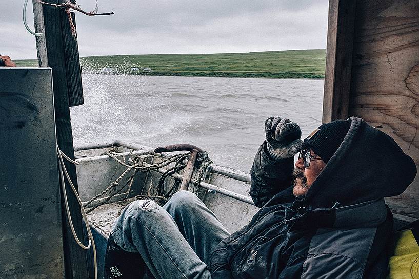 Столяр Карл Кассарули плывет на лодке по реке Нинглиг в строящийся поселок Метавик, где ему предстоит работать