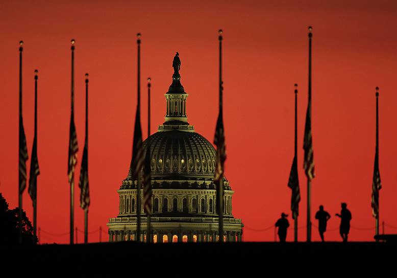 Вашингтон, утро 3 октября занимается над куполом Капитолия с приспущенными флагами 
