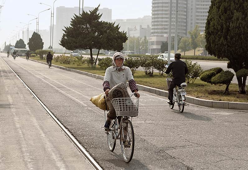 Редкий кадр — горожанка на велосипеде. В Северной Корее он считается мужским средством передвижения, городские девушки пользуются им очень редко 
