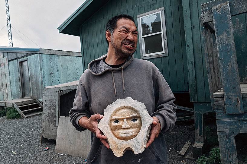 Тут живут в основном инупиаты -- эскимосская народность. Несмотря на то что в деревне около 500 человек, принять душ и постирать можно только в одном месте
На фото: местный житель демонстрирует свое изделие, которое он вырезал из кости кита