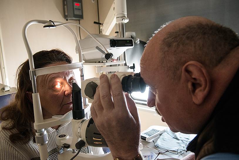 Офтальмолог Олег Федтченко обследует пациентку. В поезде современное оборудование, такого нет во многих районных больницах