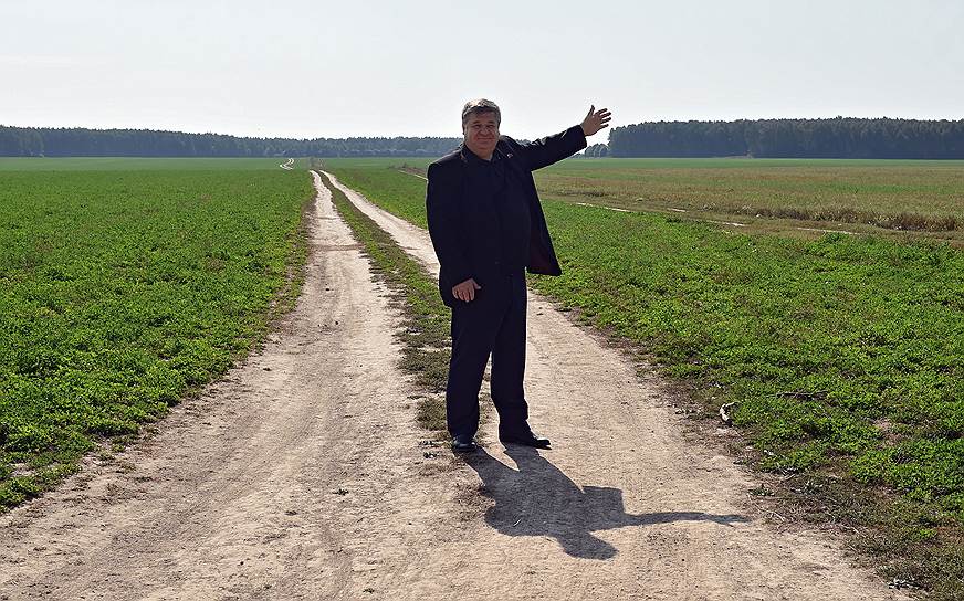 Глава ООО «Родина» Михаил Баранов показывает на участки у кромки поля, запланированные под строительство домов