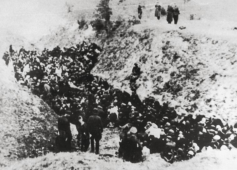 Польские евреи перед уничтожением под охраной немецких солдат в окрестностях концлагеря Собибор или концлагеря Белжец. Снимок 1941 года
