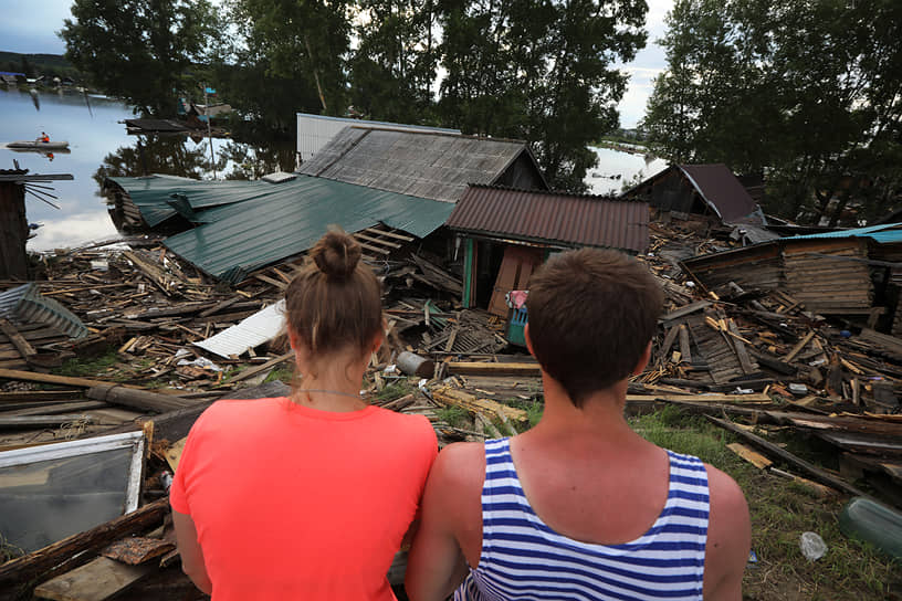 Жители Тулуна около дома, разрушенного наводнением