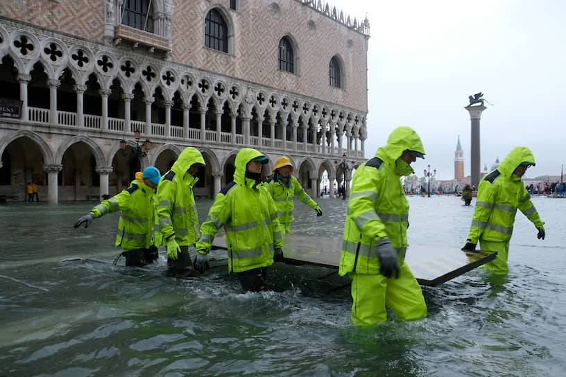 Рабочие во время наводнения в Венеции