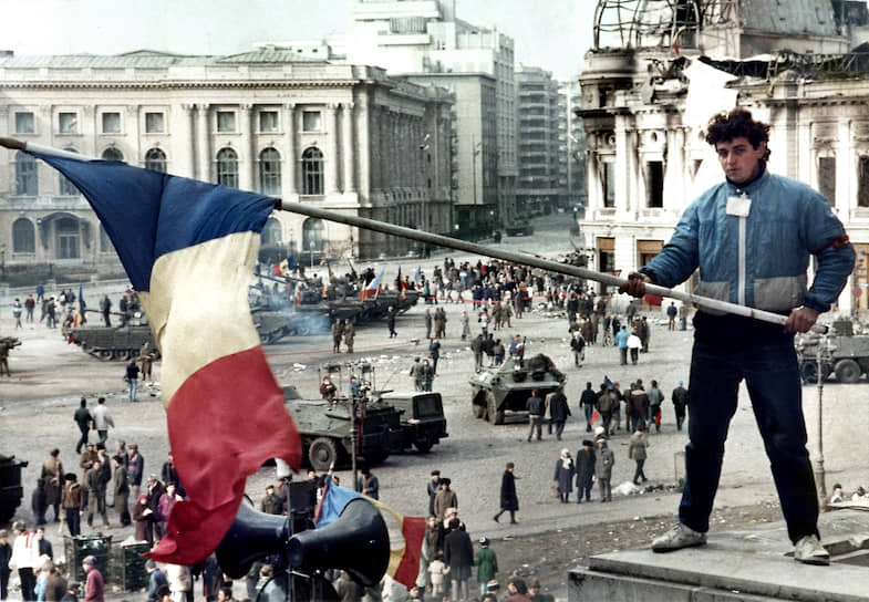 Утро после революции: молодой человек с флагом Румынии на балконе здания, где был ЦК компартии. Впереди — будни
