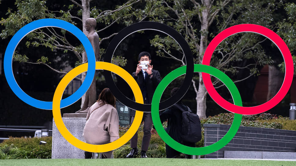 Люди в масках рядом с Японским олимпийским музеем. Помешает ли коронавирус главному спортивному событию сезона?