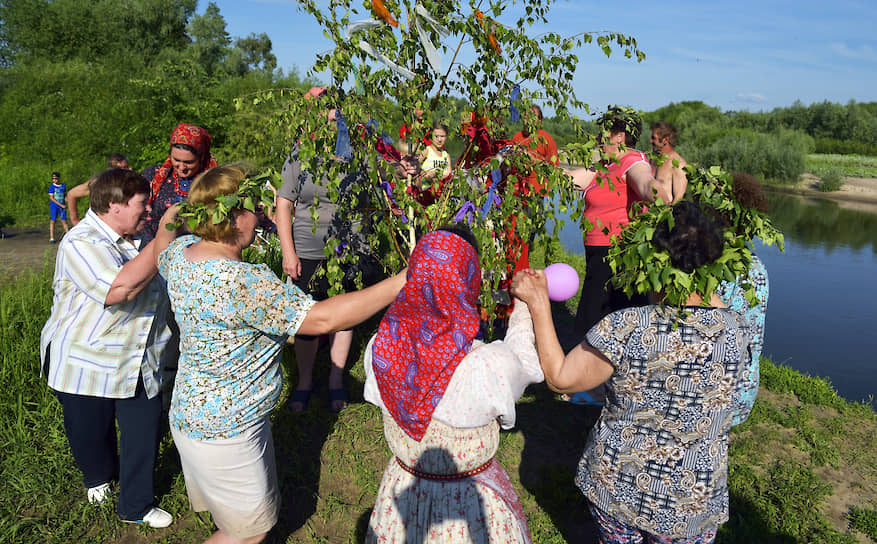 Участники праздника пляшут и поют вокруг березки — деревце украшают, плетут ему «косы»