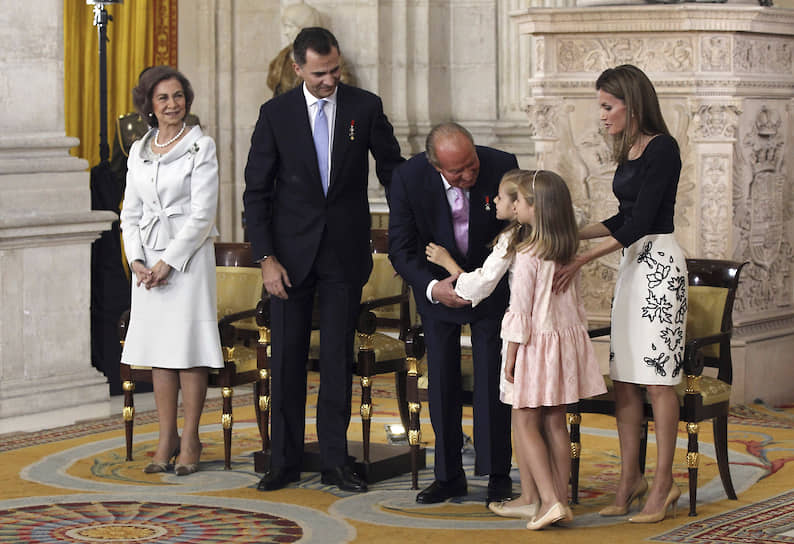 На церемонии отречения 18 июня 2014-го слева направо: королева София, принц Филипп, король Хуан Карлос, склонившийся к инфантам Леоноре и Софии; принцесса Летисия 